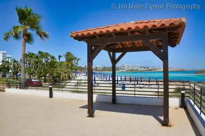 a pavilion at the beach with a view of the ocean at Nissi 3 Pool Access Garden Apartment in Ayia Napa