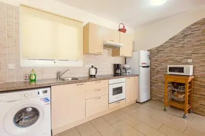 a kitchen with a washing machine and a refrigerator at Nissi 3 Pool Access Garden Apartment in Ayia Napa