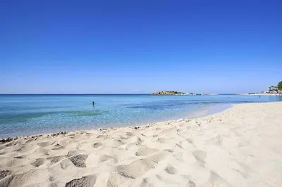 a person standing in the water on a beach at Nissi Golden Sands Family Apartment in Ayia Napa