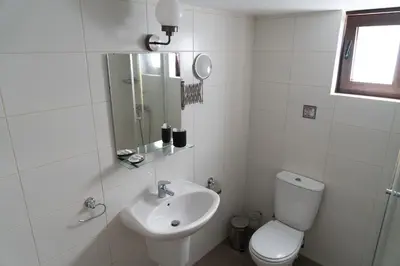 a white bathroom with a toilet and a sink at Zangoulos Mountain in Kakopetria