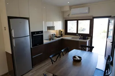 a kitchen with a wooden table and a refrigerator at Zangoulos Mountain in Kakopetria