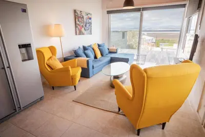 a living room with yellow chairs and a blue couch at LIMASSOL AKROTIRI BEACH VINE COTTAGE a in Limassol