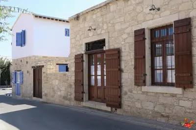 a stone building with wooden doors and windows at Rothkia's Home in Parekklisha