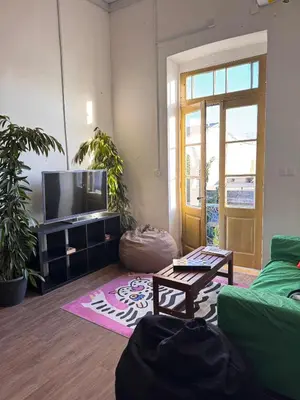 a living room with a couch and a tv at Bee Hostel in Limassol
