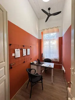 an office with a desk with two chairs and a ceiling fan at Bee Hostel in Limassol