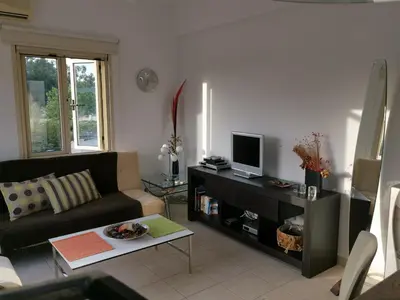 a living room with a couch and a tv at Garden Luxury Apartment Ayia Napa in Ayia Napa