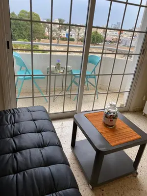a room with a coffee table and a view of a patio at Larnaca Comfort Rooms With Smart TV & Netflix in Larnaka