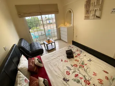 a bedroom with a bed and a chair and a window at Larnaca Comfort Rooms With Smart TV & Netflix in Larnaka