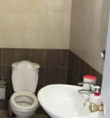 a bathroom with a white toilet and a sink at Protaras Tennis and Country Club in Protaras