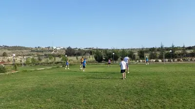 a group of people playing soccer in a field at Protaras Tennis and Country Club in Protaras