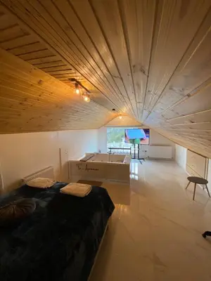 a bedroom with a large bed in a room with a table at Aprosmeno Jacuzzi House 2 in Agros