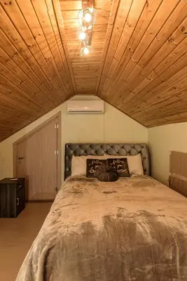 a bedroom with a large bed with a wooden ceiling at Aprosmeno Jacuzzi House 2 in Agros