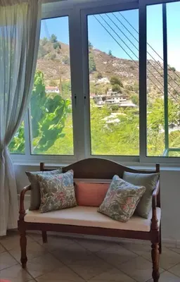 a couch sitting in a room with windows at Moutoullas Mountain Views in Moutoullas