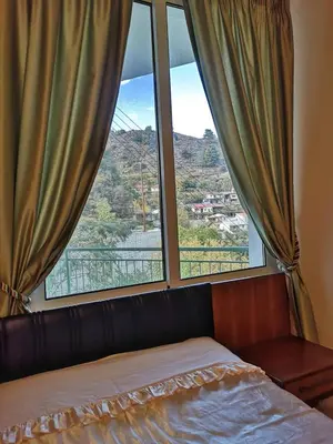 a bed in a room with a large window at Moutoullas Mountain Views in Moutoullas