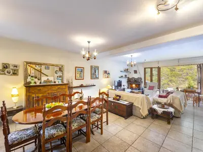 a living room with a table and a dining room at Troodos Riverside Cottage in Kato Amiandos