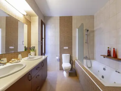 a bathroom with two sinks and a toilet and a shower at Troodos Riverside Cottage in Kato Amiandos