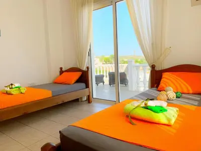 a bedroom with two beds and a balcony at Carilisto Villas Big 4 Bedrooms in Center of Ayia Napa in Ayia Napa