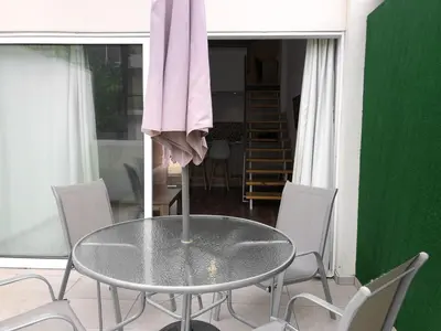 a table in a room with chairs and a pink towel at Cozy Loft Apartment in Ayia Napa