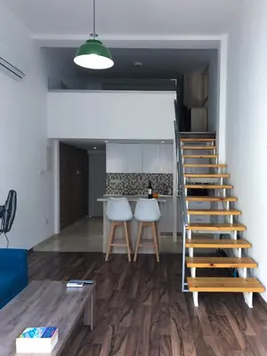 a living room with a staircase and a kitchen at Cozy Loft Apartment 2 in Ayia Napa