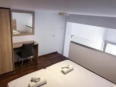 a bedroom with a bed and a desk and a chair at Cozy Loft Apartment 2 in Ayia Napa