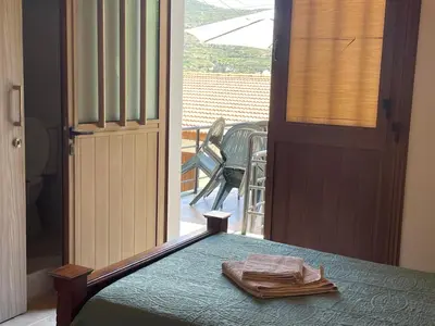 a bedroom with a bed and a door to a porch at Omodos Katoi Holiday Homes in Omodos