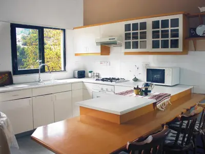 a kitchen with white cabinets and a wooden table at Laoni Guest House in Moutoullas, Marathasa in Limassol