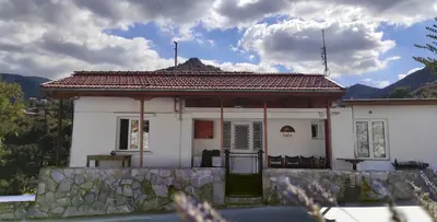 a small white house with a stone wall at Laoni Guest House in Moutoullas, Marathasa in Limassol