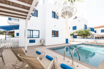 a villa with a swimming pool and patio furniture at St Nicolaos Villa Ekaterina 3 bdrm in Protaras