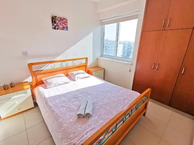 a bedroom with a bed with a pair of shoes on it at License to Chill Apartment in Larnaka