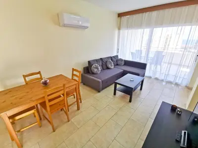 a living room with a couch and a table at License to Chill Apartment in Larnaka