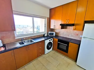 a kitchen with a sink and a washing machine at License to Chill Apartment in Larnaka