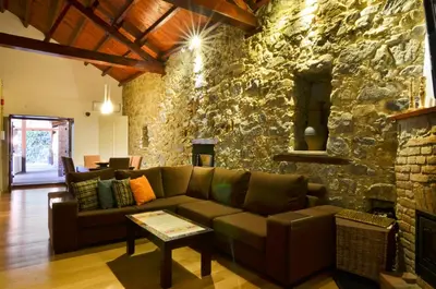 a living room with a couch and a stone wall at To Kastri in Kalopanayiotis
