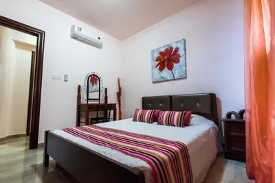 a bedroom with a bed with a striped blanket on it at Luxury Villa Regina in Protaras