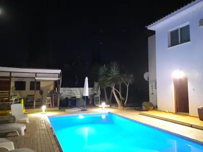 a swimming pool in front of a house at night at Villa Anastassia in Ayia Napa