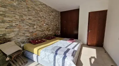a bedroom with a bed and a brick wall at The Stone Villa in Pissouri
