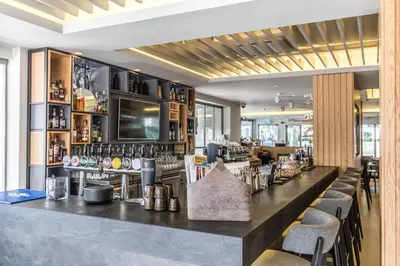 a bar in a restaurant with a counter and chairs at Liquid Hotel Apartments in Ayia Napa