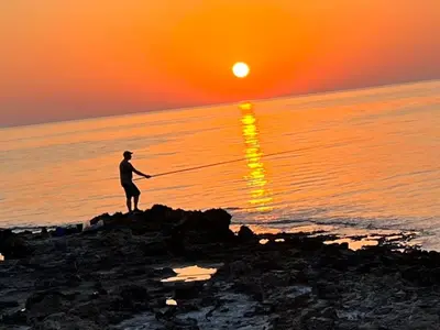 a man standing on the beach watching the sunset at Panthoma Casa in Ayia Napa