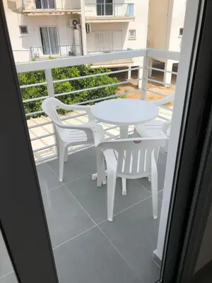a balcony with a white table and chairs on a patio at Katalimata Court in Ayia Napa