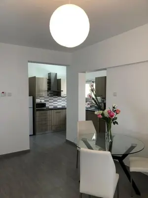 a dining room and kitchen with a glass table and white chairs at Katalimata Court in Ayia Napa