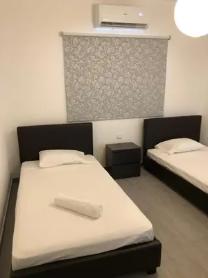 a room with two beds with white sheets at Katalimata Court in Ayia Napa