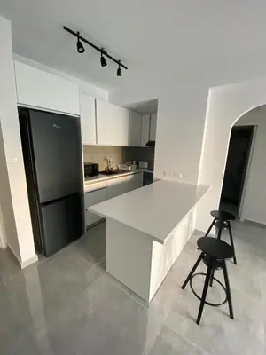 a kitchen with a white counter and a black refrigerator at Greco 1 Bedroom Apartment in Limassol