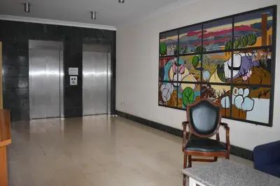 a chair in a waiting room with a painting on the wall at Klimentos Flat 59 in Nicosia