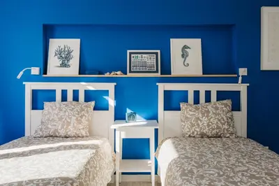 a bedroom with blue walls and two beds and a table at Zima Blue in Zygi