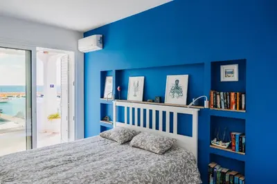 a blue bedroom with a bed and bookshelves at Zima Blue in Zygi