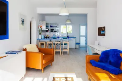 a living room with orange chairs and a kitchen at Zima Blue in Zygi