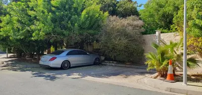 a white car parked on the side of a street at Villa Larnaca Bay Resort in Voroklini