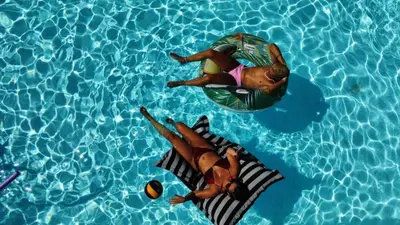 two people floating in a pool on a raft in the water at Kasparis View Residence in Pano Lefkara