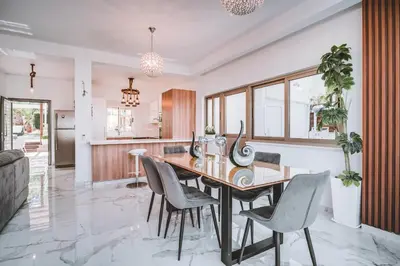 a kitchen and dining room with a wooden table and chairs at SunnyVillas: 4BR Villa☆Private Pool + Jacuzzi - Villa Amelie in Protaras