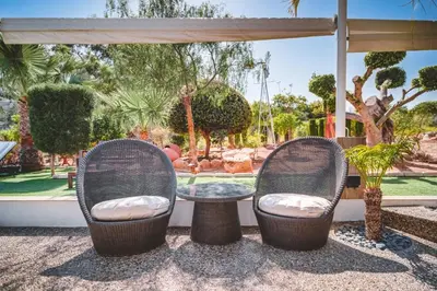 two chairs and a table in front of a garden at SunnyVillas: 4BR Villa☆Private Pool + Jacuzzi - Villa Amelie in Protaras