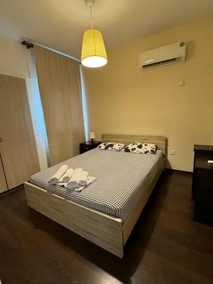 a bedroom with a bed with slippers on it at Magic Sea Apartments in Larnaka